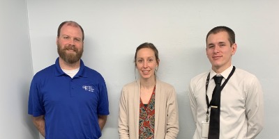 three professional looking people posing for photo